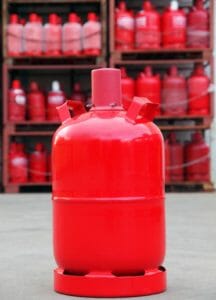 Rote 11kg Pfandgasflasche im Vordergrund auf Betriebshof eines Gashändlers