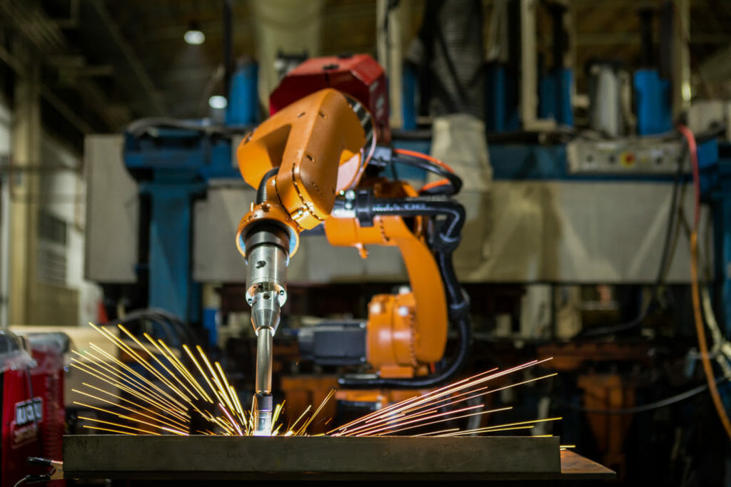 Orangener Laser Roboter schweißt Werkstück unter Funken