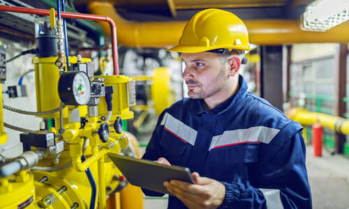 Sachverständiger prüft gelbe Spezialgas Leitungen in einem Industriegebäude