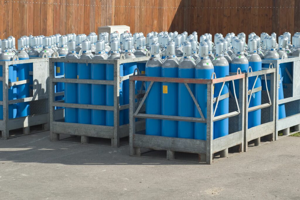Gasflaschen in Gitterboxen auf einem Industrieplatz